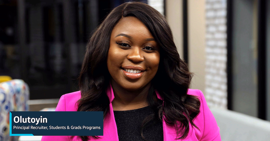 Capital One associate Olutoyin, Principal Recruiter, Students & Grads Programs, stands inside wearing a hot pink blazer and smiles